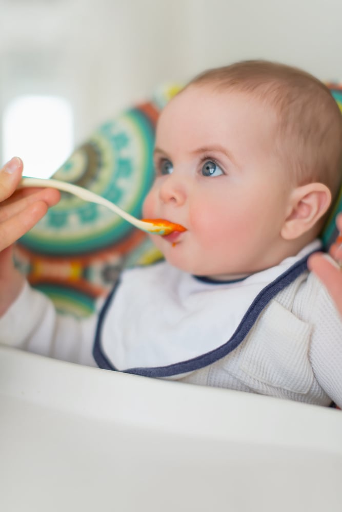 Cute baby eating puree
