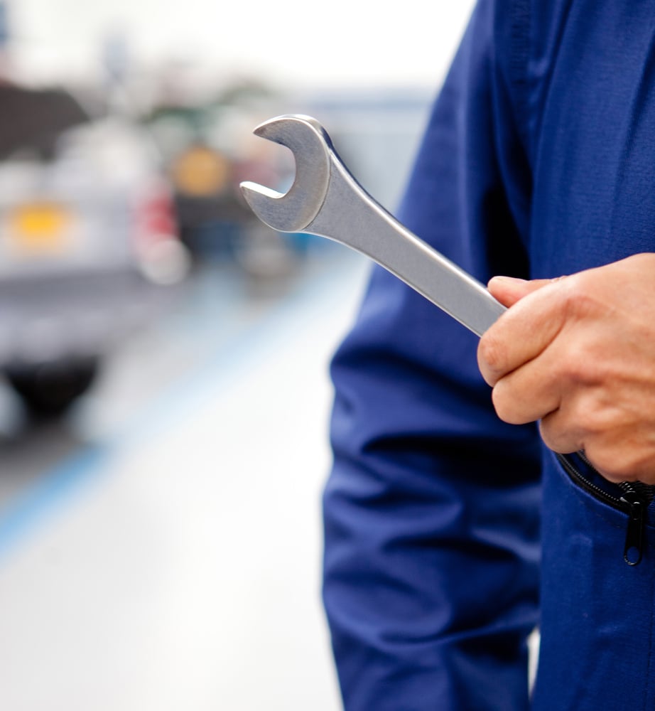 Mechanic with his tool holding a wrench at a garage