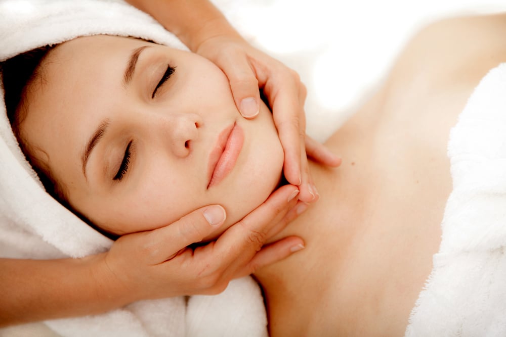 Woman at a spa getting a massage in her face